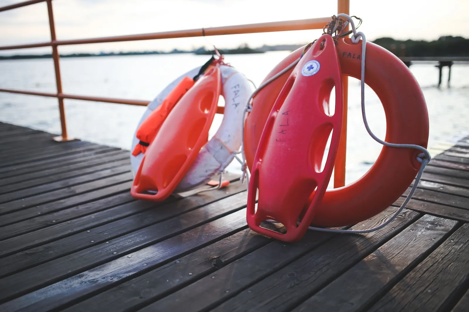 Close-up of lifebuoys and safety equipment on a lake dock providing serene waterside ambiance.